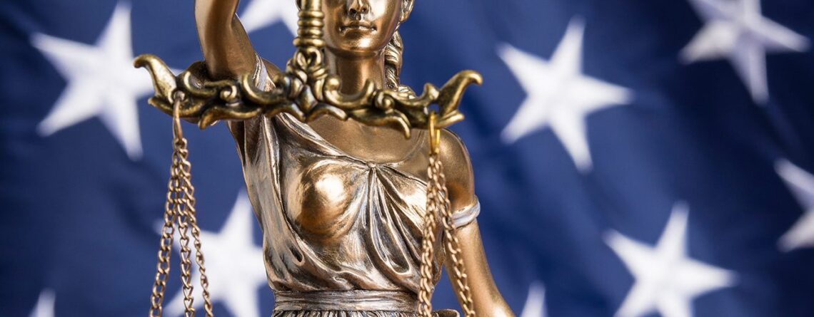 Lady justice statue with background image of the american flag