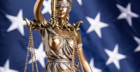 Lady justice statue with background image of the american flag