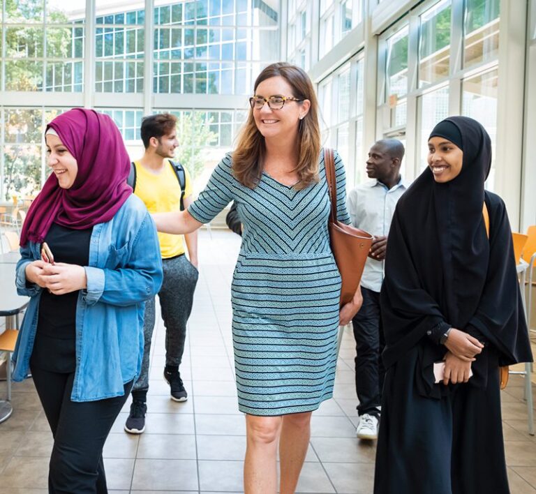 Mary Helen O'Connor walking with students on Clarkston Campus