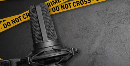 Image of a podcast microphone with yellow crime scene tape on a grey background