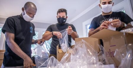 Georgia State and Perimeter College students Watema Emmanual, Mohamad Alo and Mohammad Tamer bag supplies