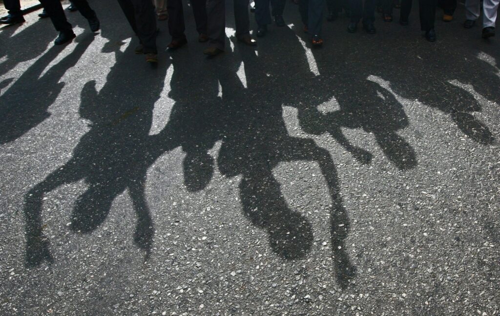 Protesters cast a shadow as they march on a street