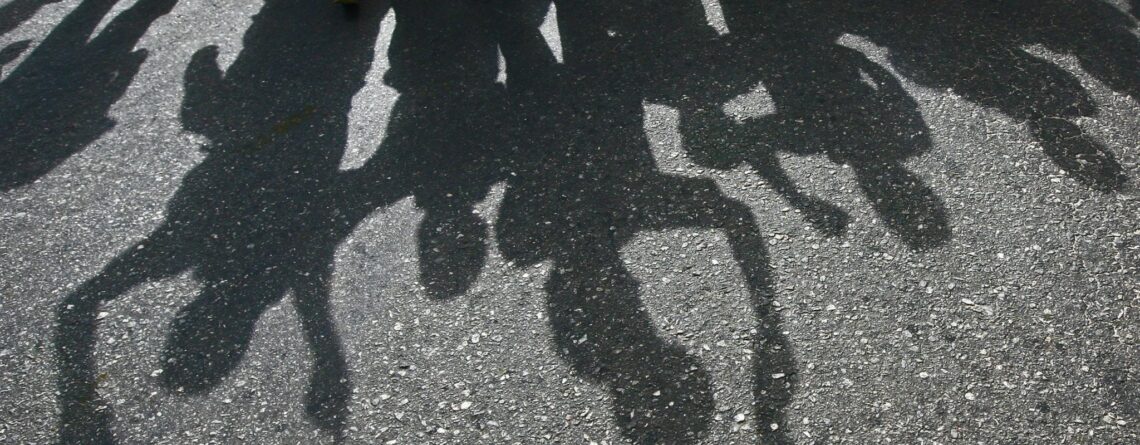 Protesters cast a shadow as they march on a street