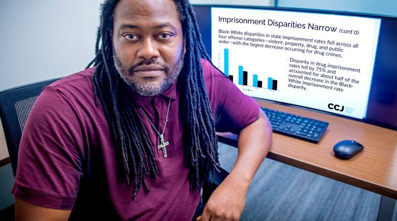 Thaddeus Johnson poses in his office