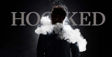 Man vaping in front of word "Hooked"